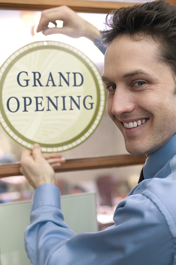 Man with grand opening sign